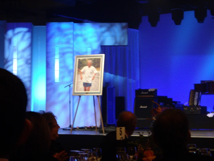 the presenter is standing on stage in front of a group