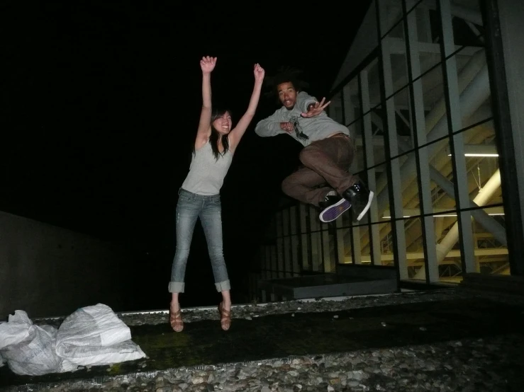 a couple of women standing next to each other on top of a cement floor