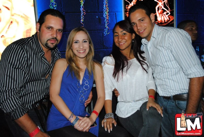 four people posing for the camera in a dark room