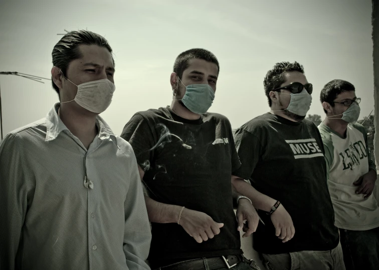 a group of men wearing face masks while standing outside