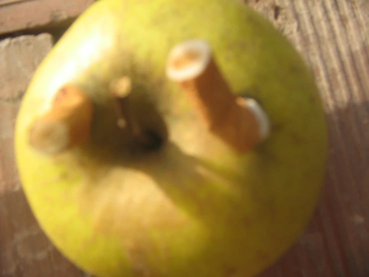 a close up image of a green apple on wood