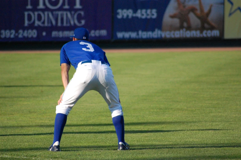 man in blue baseball uniform about to throw the ball