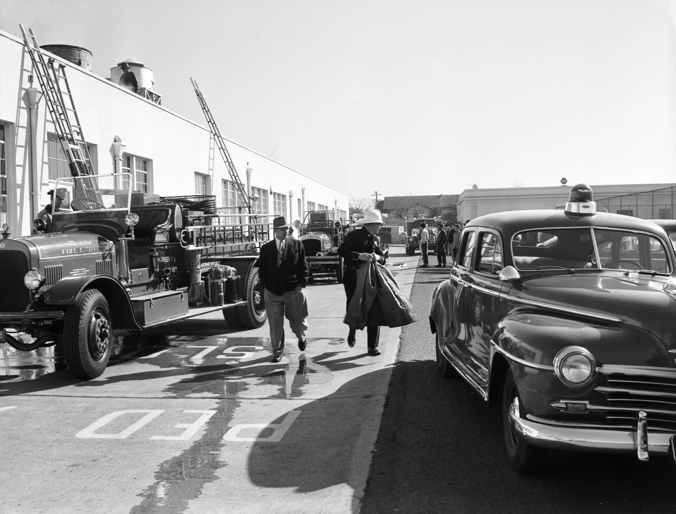 a black and white po of people near old cars