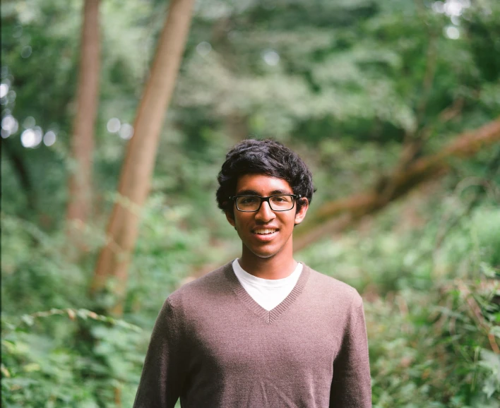 a man standing in the woods in glasses