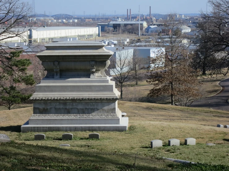 a small statue sitting in the middle of a grassy area