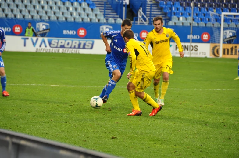 two soccer players on opposing teams playing during a soccer match