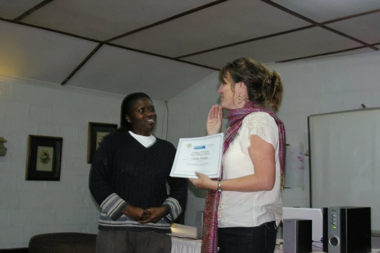 two woman holding an award in their hands