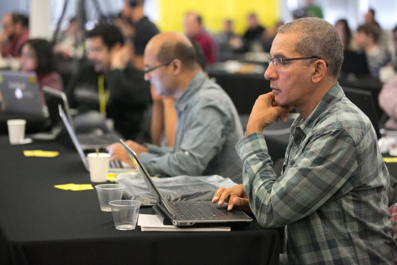 people sitting in a conference room with their laptops