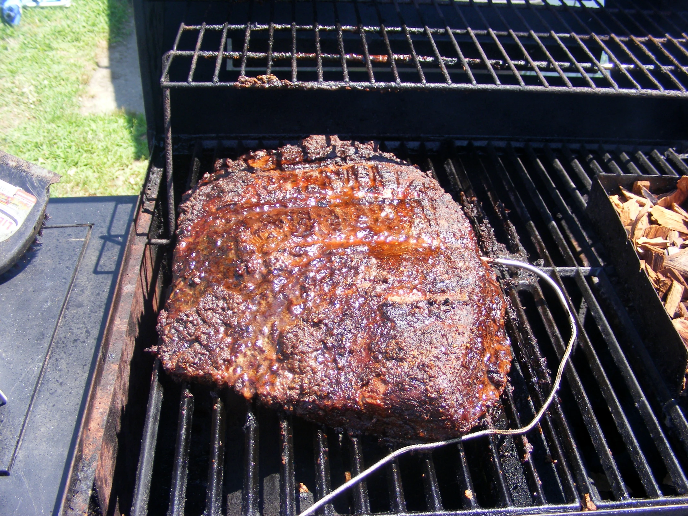 a barbecue grill has steak on it while the meat is on the grill