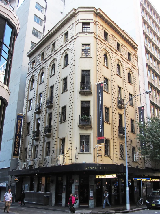 a tall building with several windows and people walking by