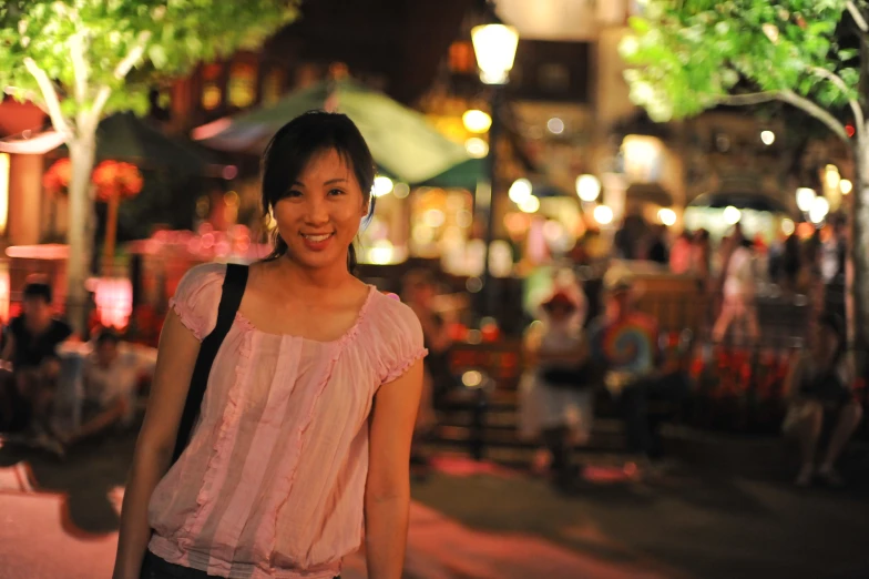 a woman in a pink shirt is smiling