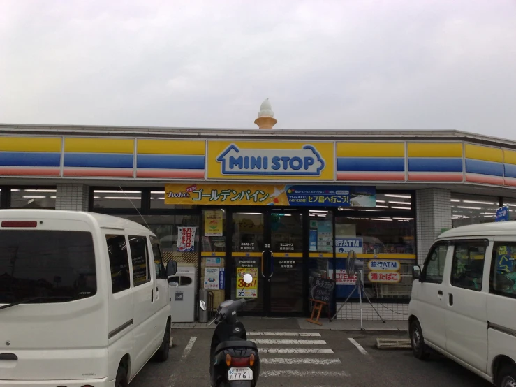 a small white van parked outside a large convenience store