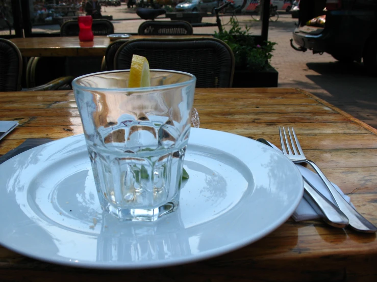 a glass filled with water sits on a plate