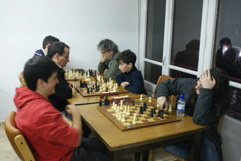 group of people play chess and check their moves