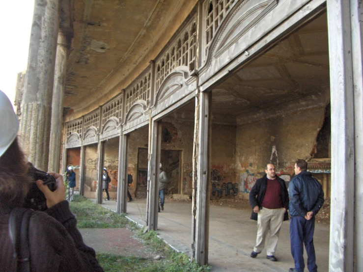 three people walking through an open doorway on the street