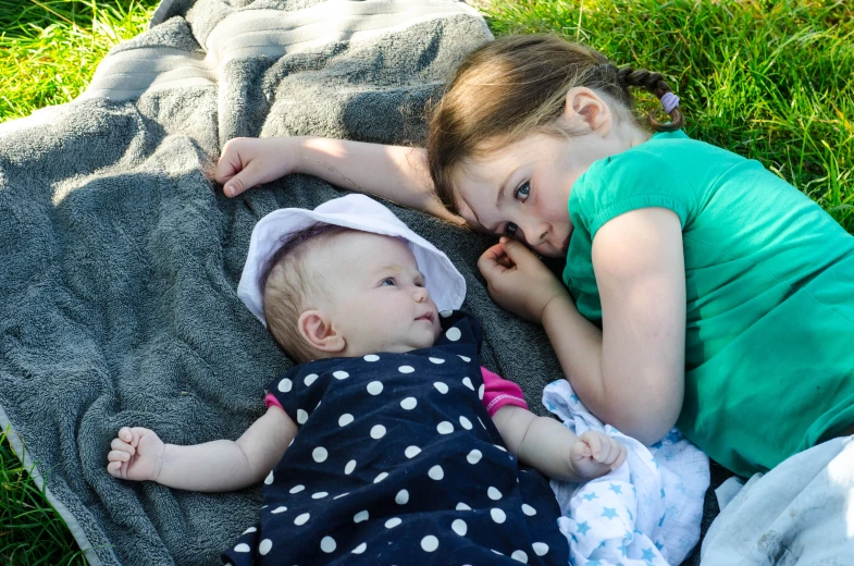 a couple of young children laying on top of a blanket