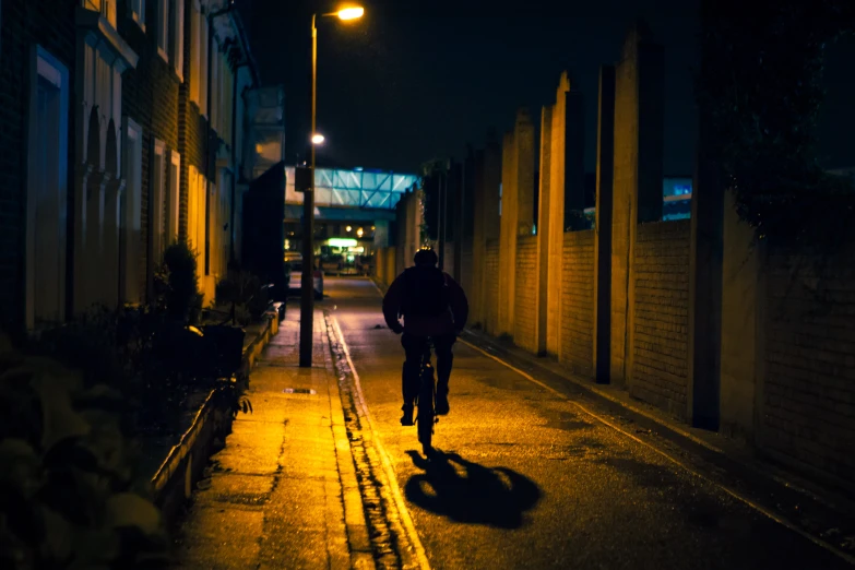 two people riding bikes on a dark alley