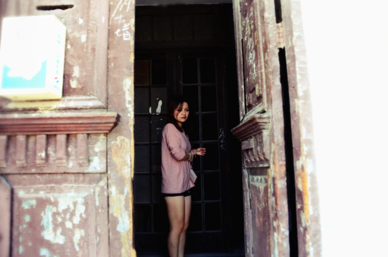 a woman in short shorts standing by an open door