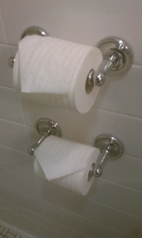 a close up view of a pair of toilet paper holders