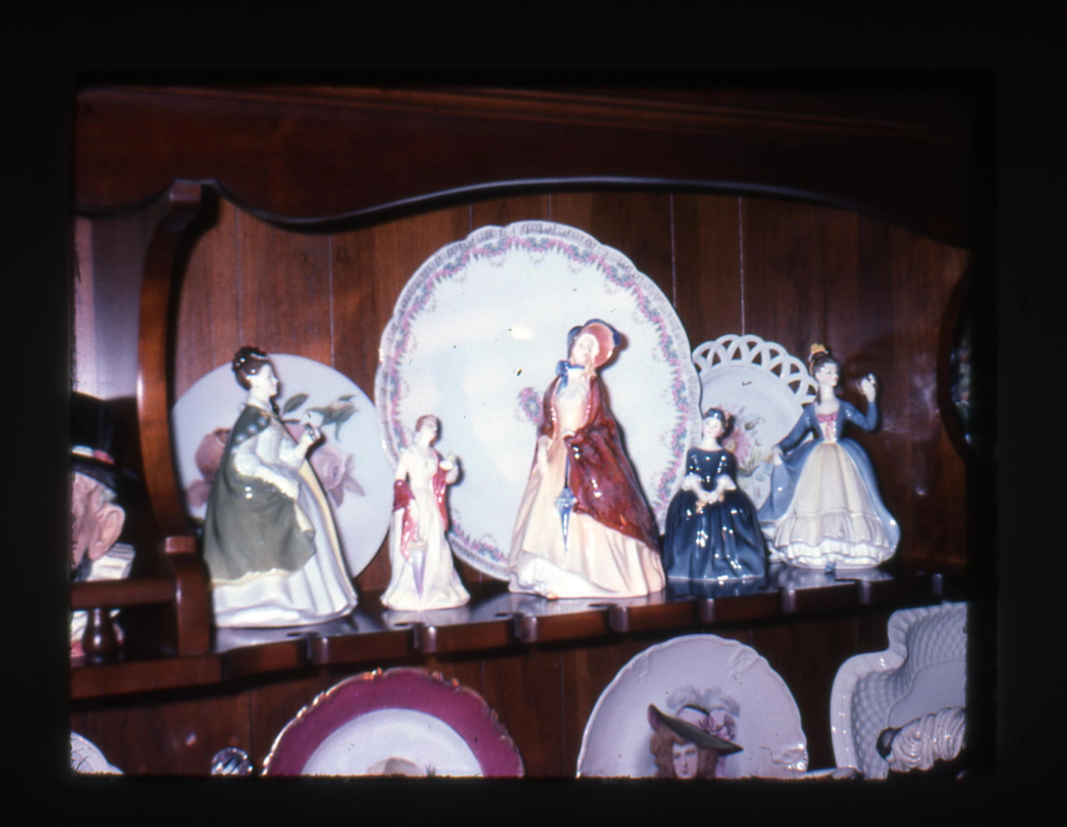 a cabinet with figurines of women and ladies plates