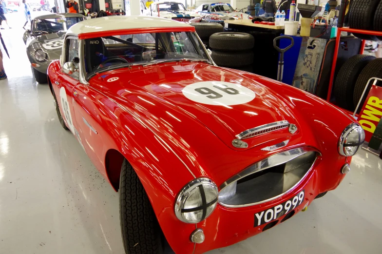 a red sports car with a white top and number 90 painted on it