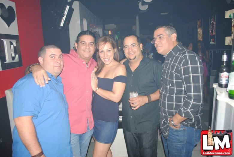 people posing for a group po in a bar