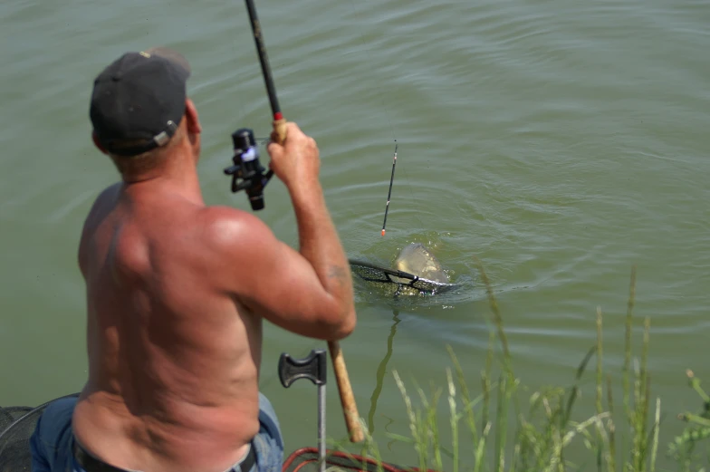 man holding a fishing pole while standing in the water