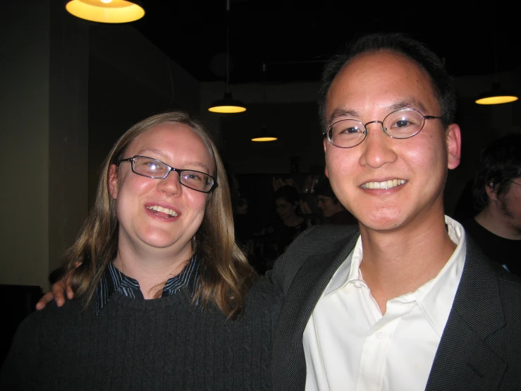 two people standing close together posing for the camera