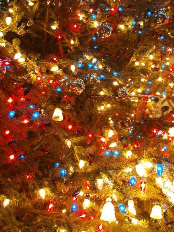 christmas tree decorated with lights and decorations in a window