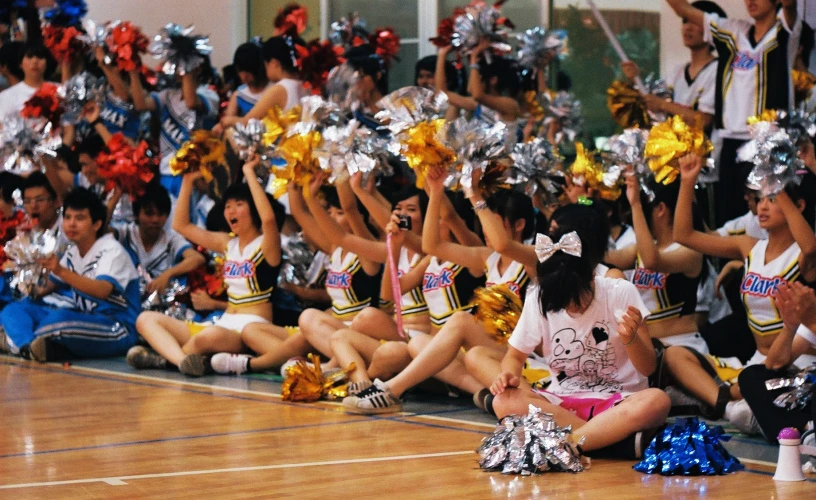 group of cheerleaders sit on the basketball court