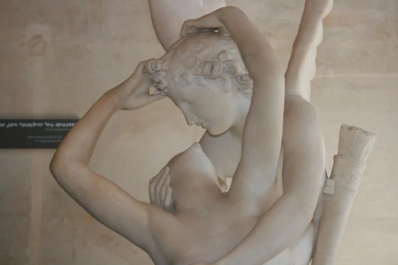 a statue of two  women are holding onto the side