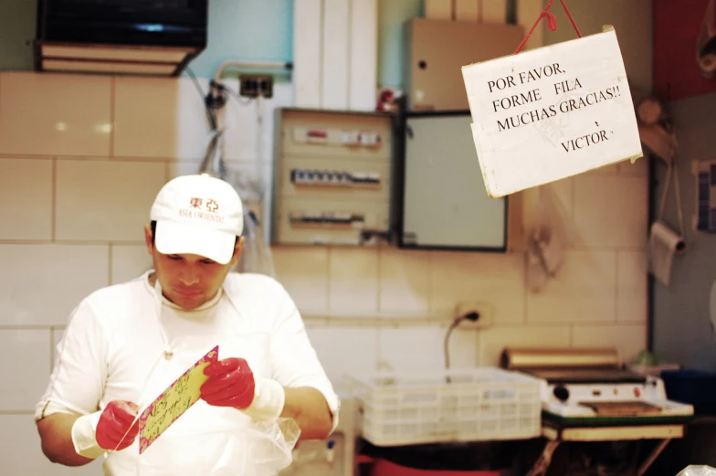 a man wearing gloves holding a large kitchen scale