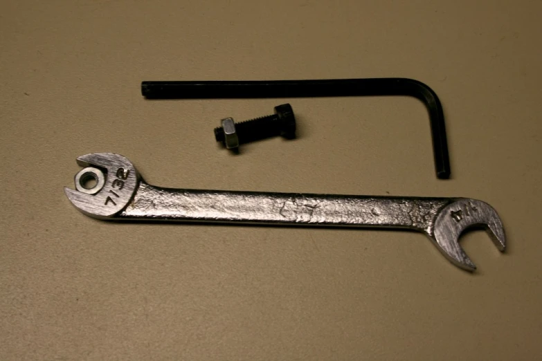 a wrench and tool that are sitting on the table