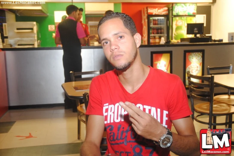 a man sitting in front of an ice cream parlor