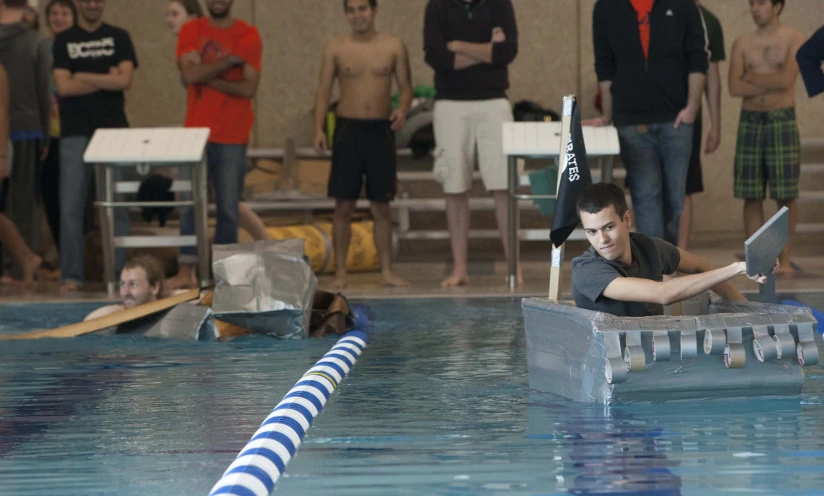 some people standing around in a swimming pool and others in the background