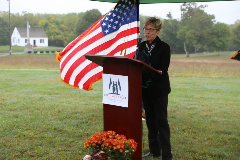 a person at a podium with an american flag