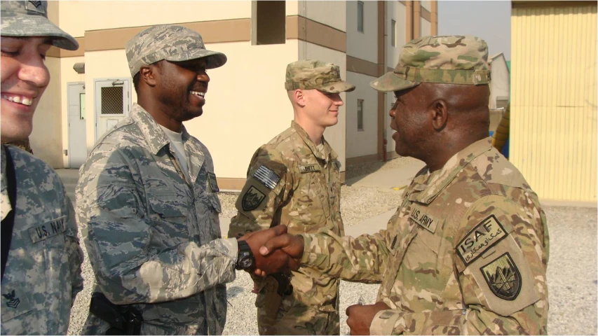 three men shaking hands in uniform outside
