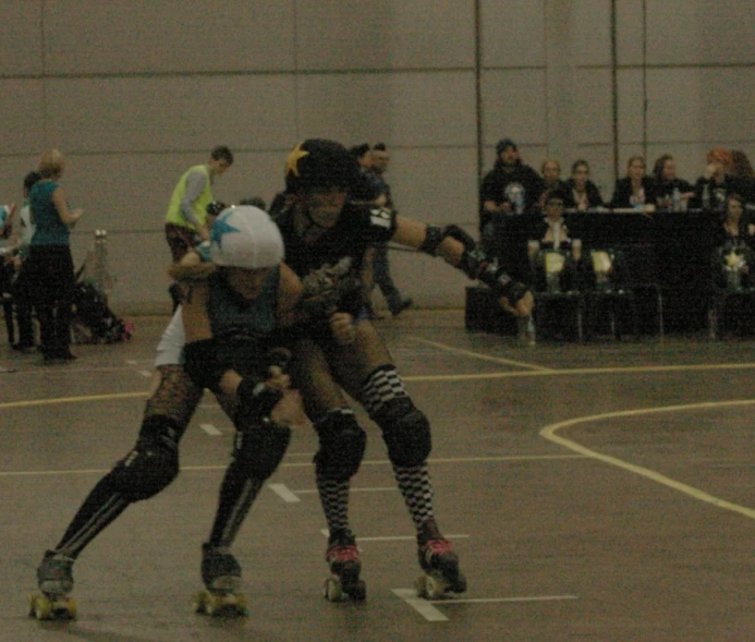 women on skateboards trying to fight in a small arena