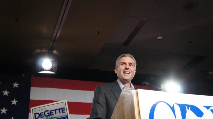 a man speaking at a campaign event and talking into a microphone