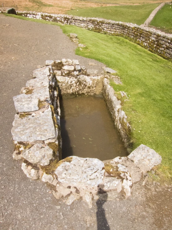 a stone well that is sitting in the ground