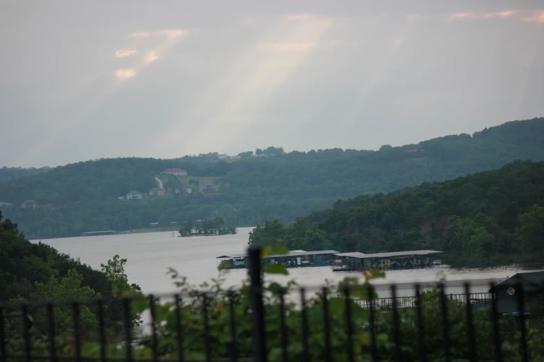 a boat floating on a lake next to lush green hills