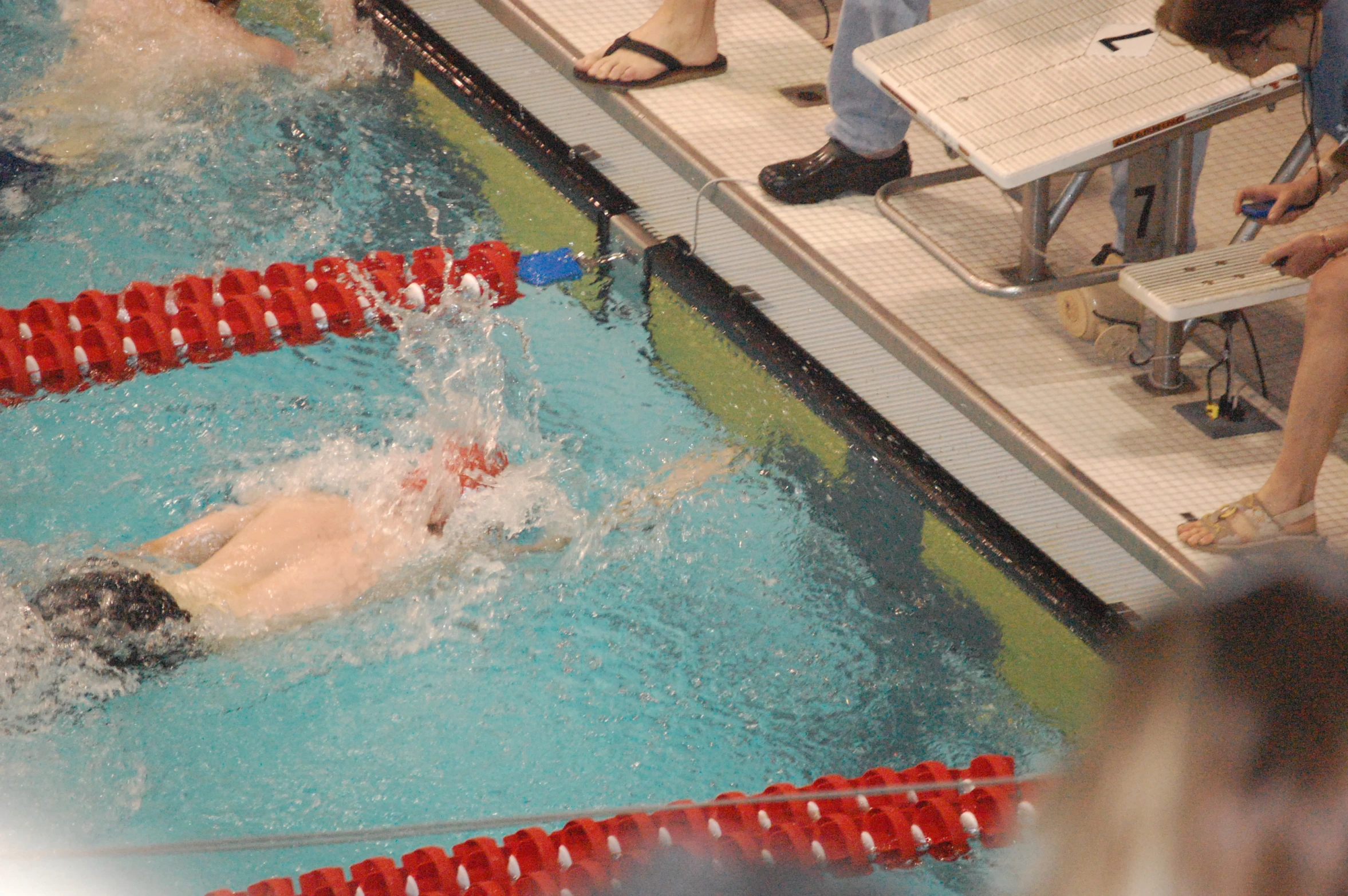 swimmers in a swimming pool and a crowd of people watching