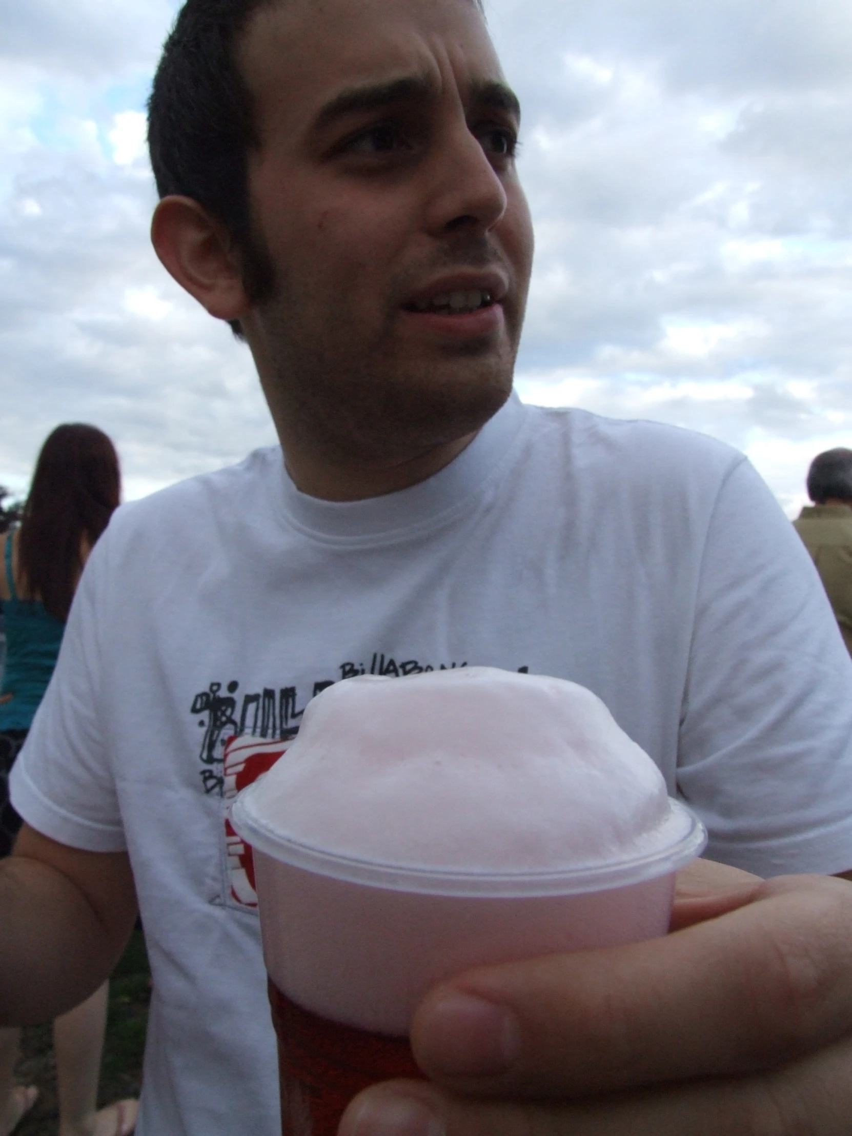 a man holding a paper cup in front of a group of people