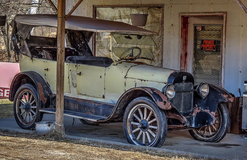 an antique car outside an old house with the door open