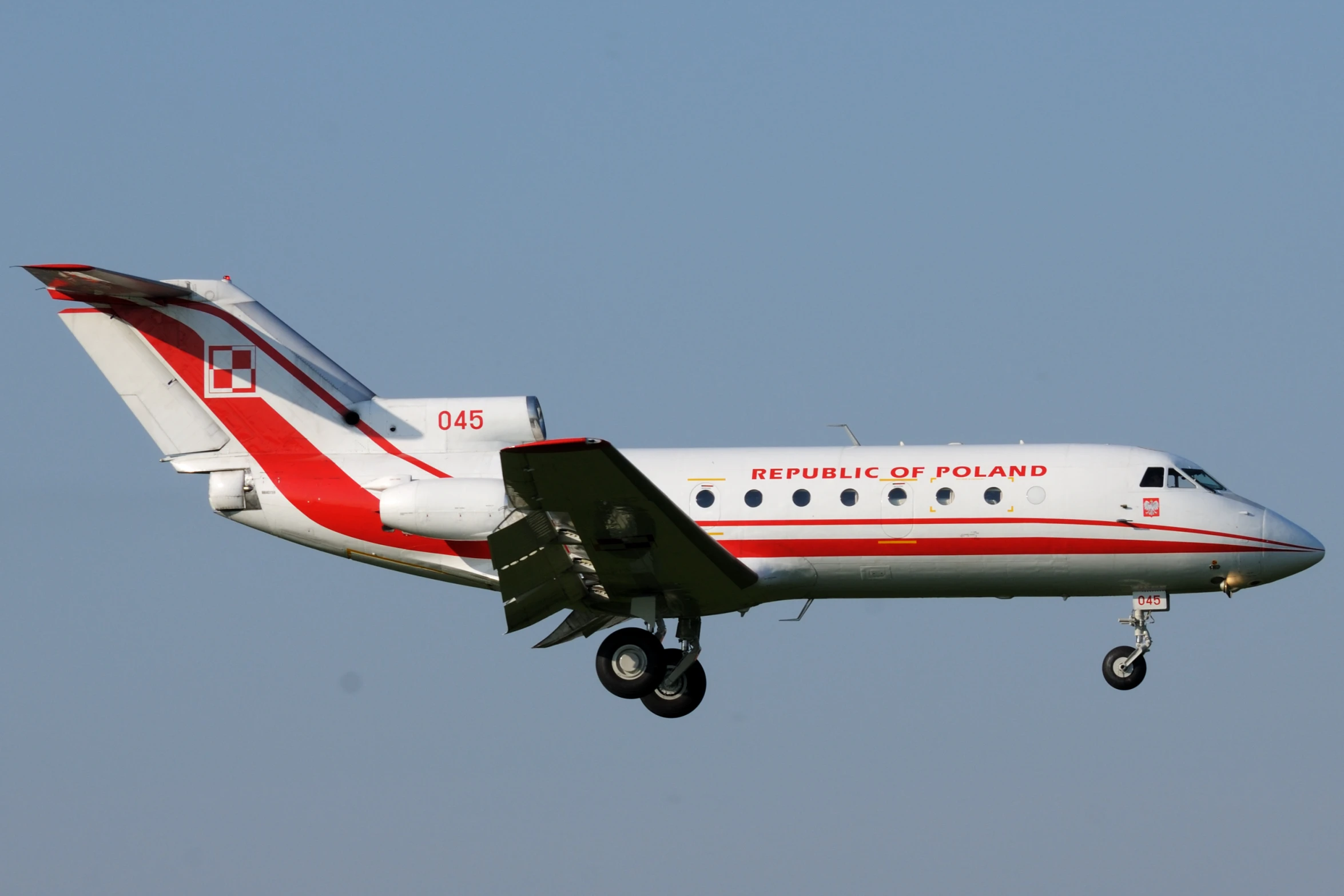 a white and red jet flying in the sky