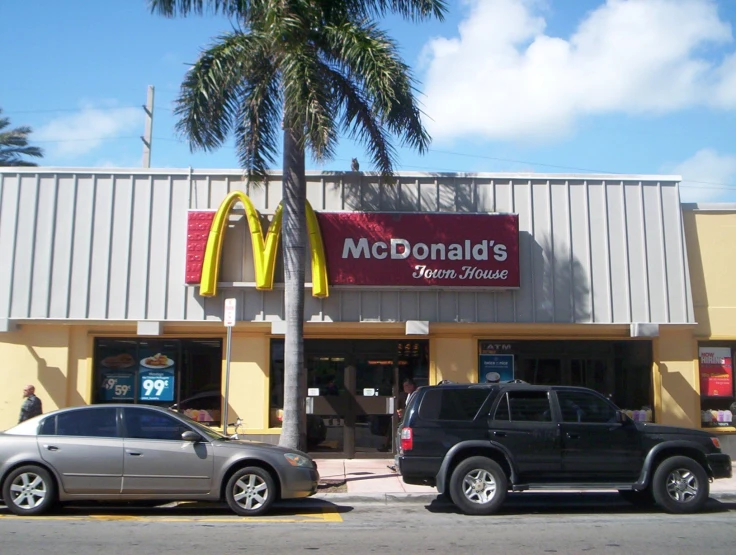 two suvs parked in front of a mcdonald's restaurant