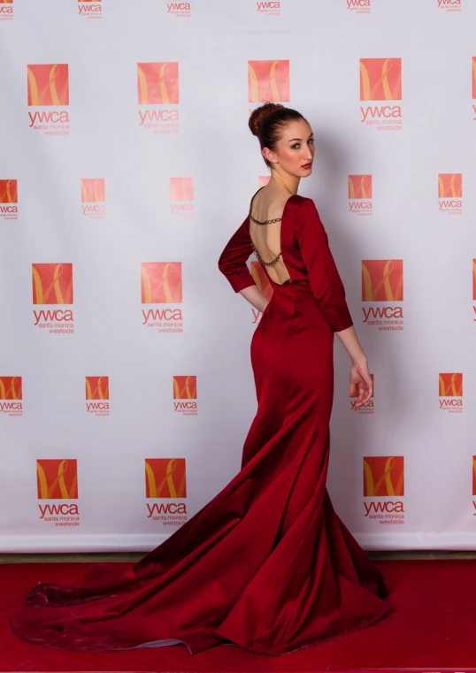 a woman posing in front of a red carpet