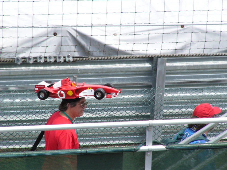 the woman is carrying a model car around her head