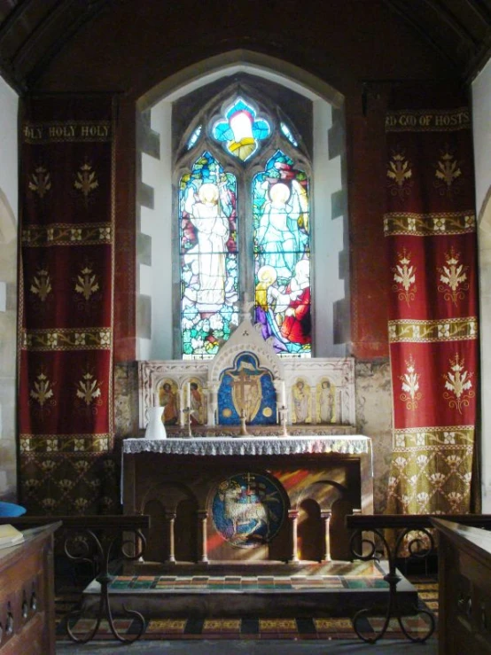 church alter with a stained glass window in the background