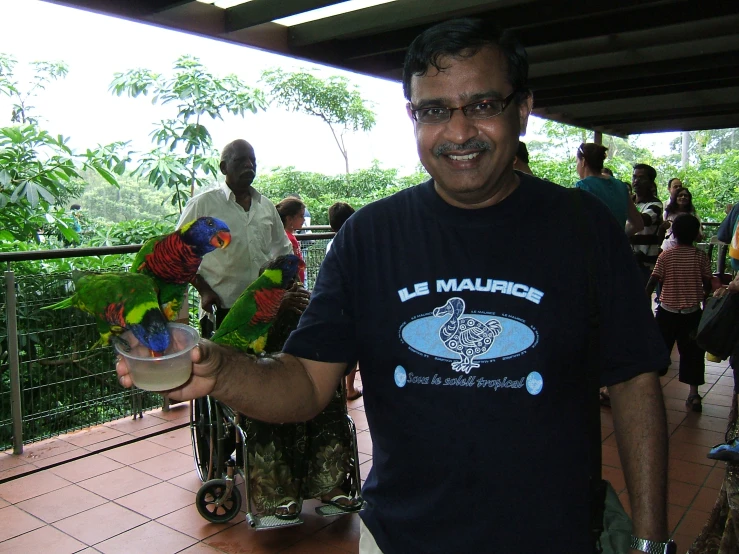 a man in blue shirt holding a vase filled with flowers
